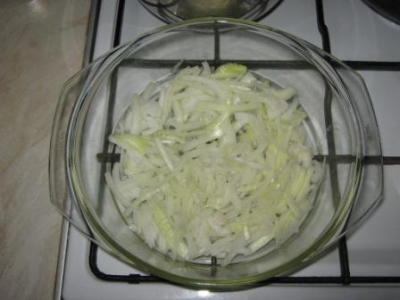 Лук режем тонкими полукольцами, укладываем на низ формы для запекания, смазанной небольшим количеством раст