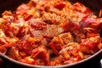 Через пару минут добавьте мясо, нарезанное крупными кубиками, посолите и поперчите