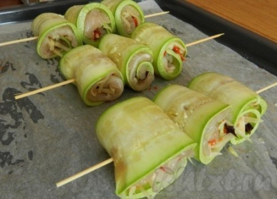 Скрутить рулетики из кабачков с куриным мясом, сколоть их шпажками и запечь при 180 градусах 25 минут