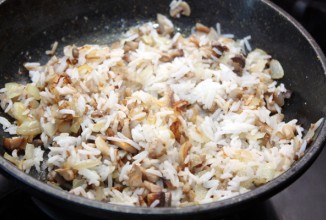 Добавить в сковородку сваренный рис, посолить, поперчить по вкусу, перемешать