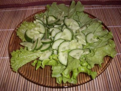 На листья салат выкладываем нарезанные огурцы