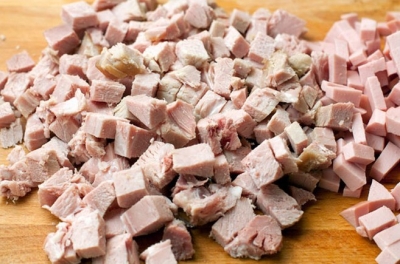 Колбасу и другие мясопродукты нарежьте мелкими кубиками и опустите в суп, продолжая варить на небольшом огне