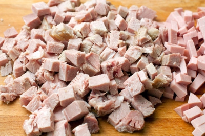 Колбасу и другие мясопродукты нарежьте мелкими кубиками и опустите в суп, продолжая варить на небольшом огне