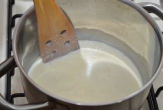 Выкидываем луковицу из молока, вливаем его тоненькой струйкой, всё время помешивая в масло с мукой